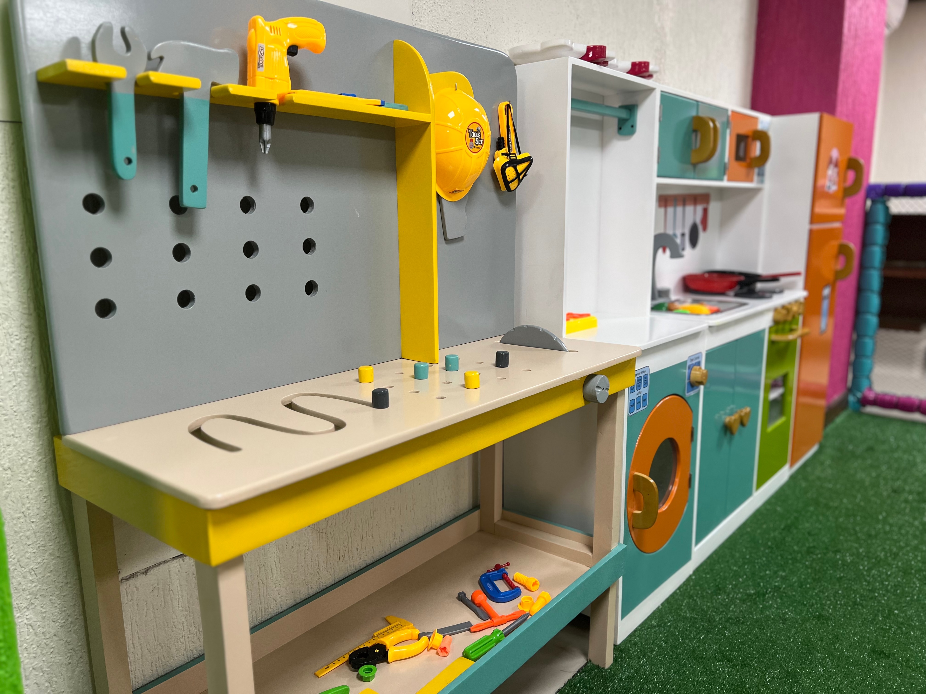 Estación temática de Chitis Club con herramientas y cocina de juego para actividades de rol.